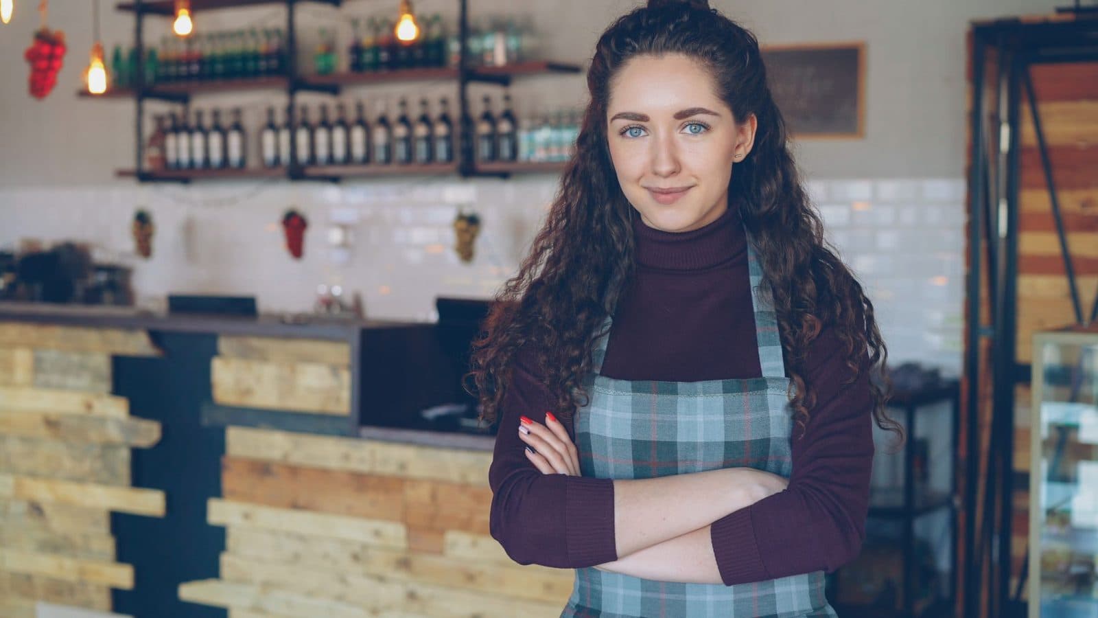 A cafe owner behind the counter of her coffee shop